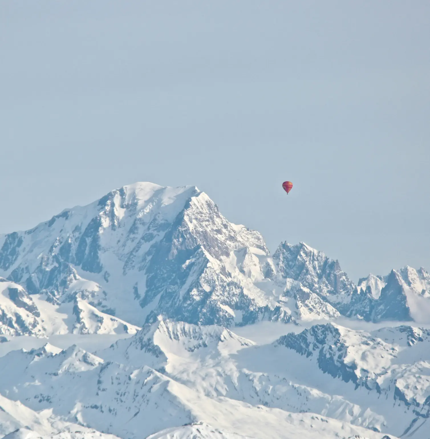 Hot air balloon over snowy mountains in Courchevel