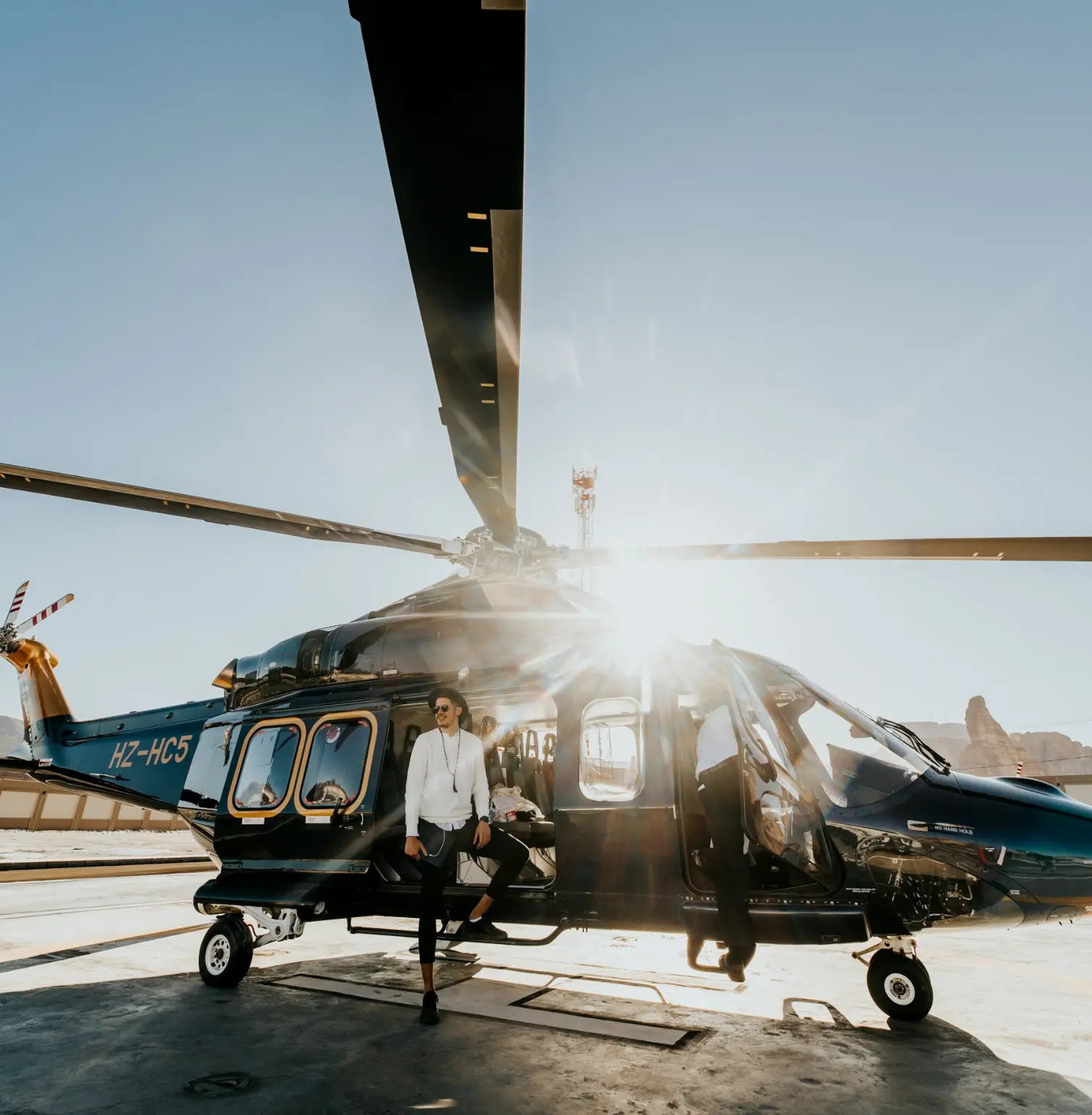 Person stepping out of a helicopter in the snowy mountains