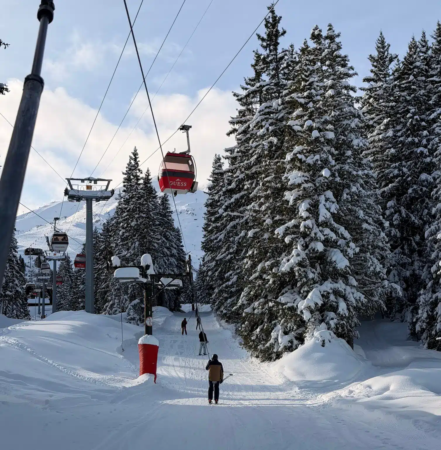 Red gondola ski lift and ski tow lift in Courchevel