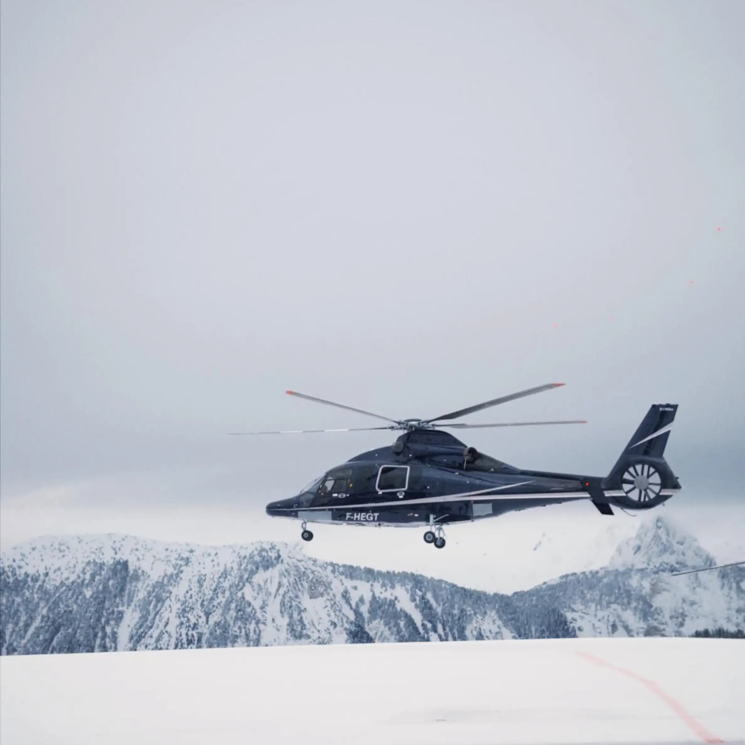 Helicopter flying over snowy mountains