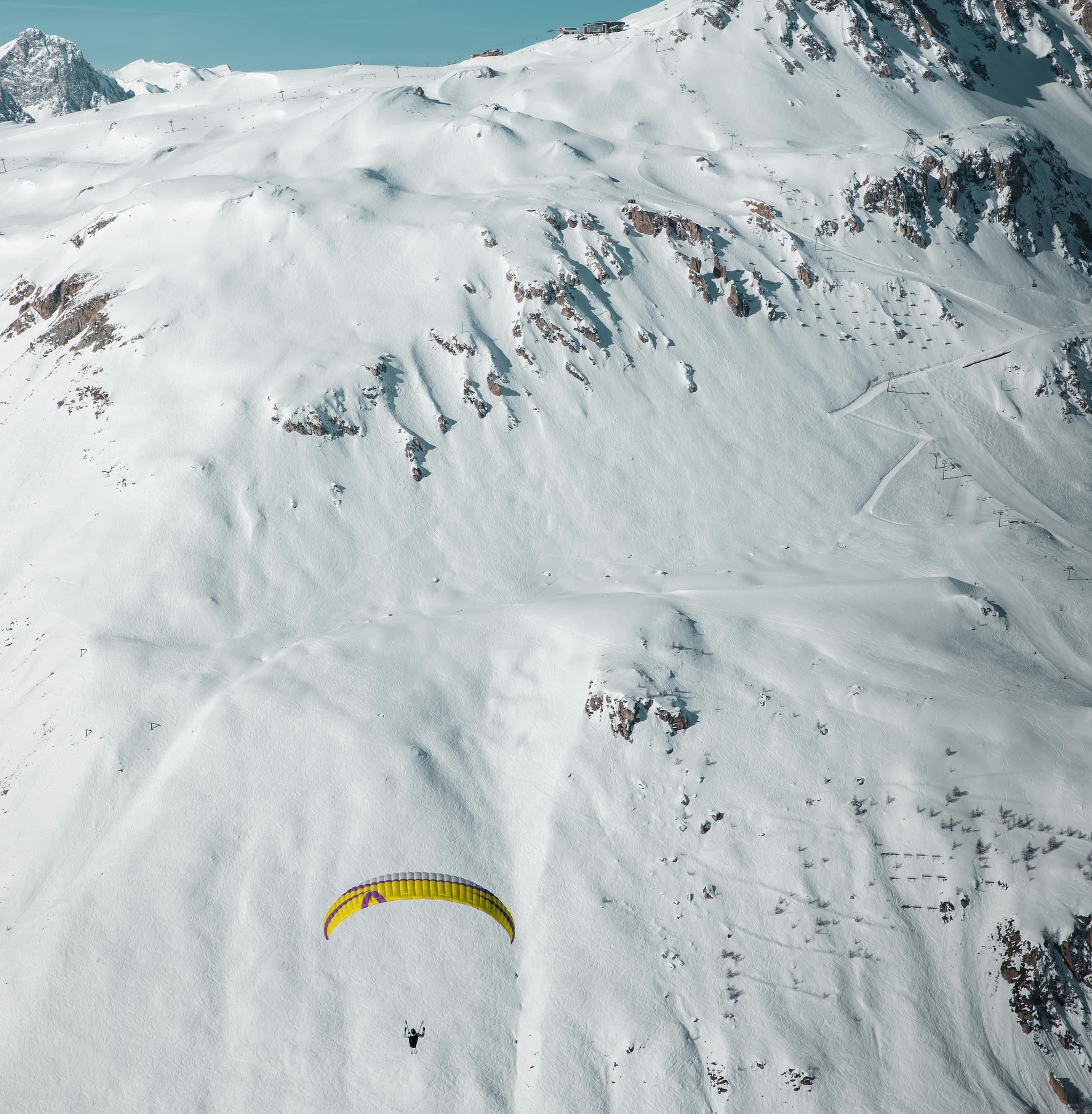 Paragliding over snowy mountains in Courchevel