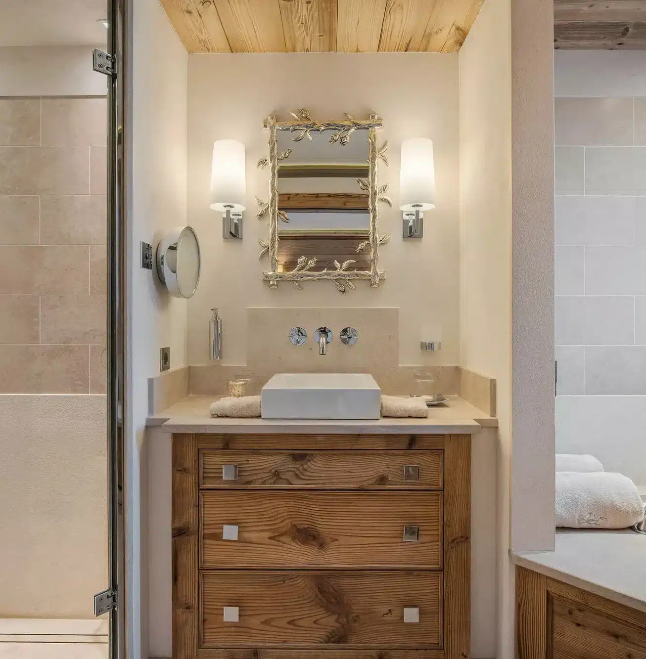 Bathroom with wooden vanity and ornate mirror in a Courchevel chalet