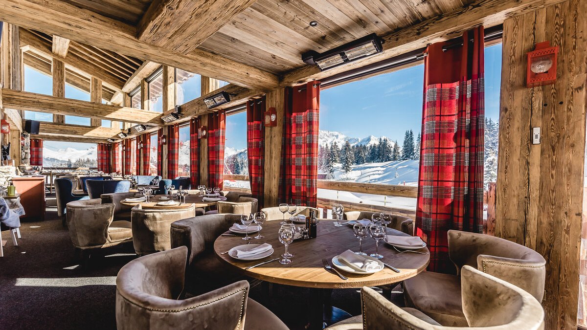Chalet dining room with tartan curtains and mountain windows at Baïes, Courchevel 1850