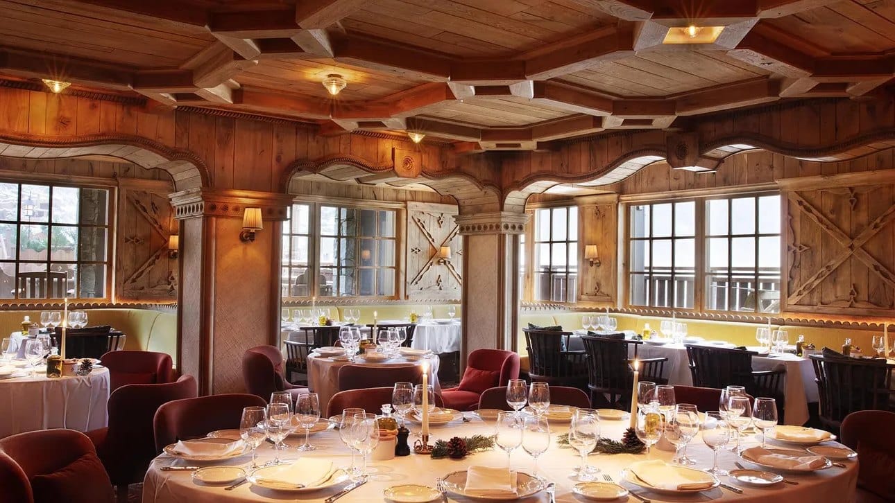 Carved-wood dining room with white linen at Loulou, inside Fouquet’s at Barrière Les Neiges, Courchevel 1850